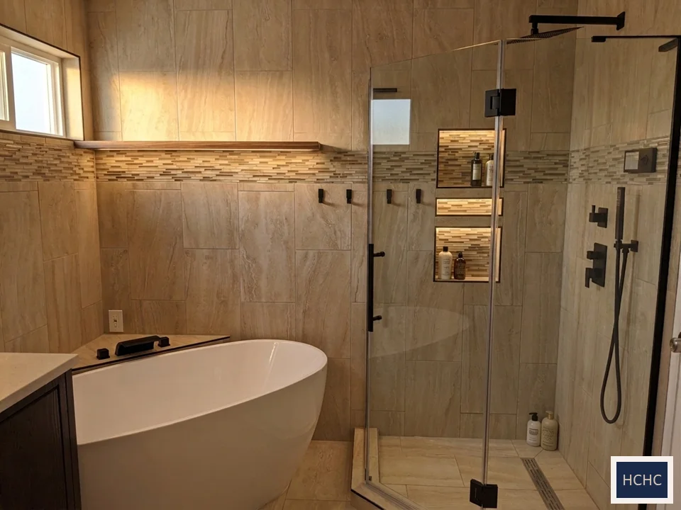 Spa primary bathroom with freestanding tub, lit shower niches, and glass shower in a Texas Hill Country home