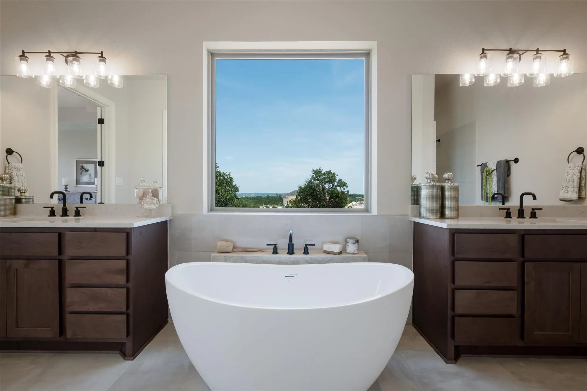 Primary bathroom with freestanding tub, Hill Country views, and espresso vanities